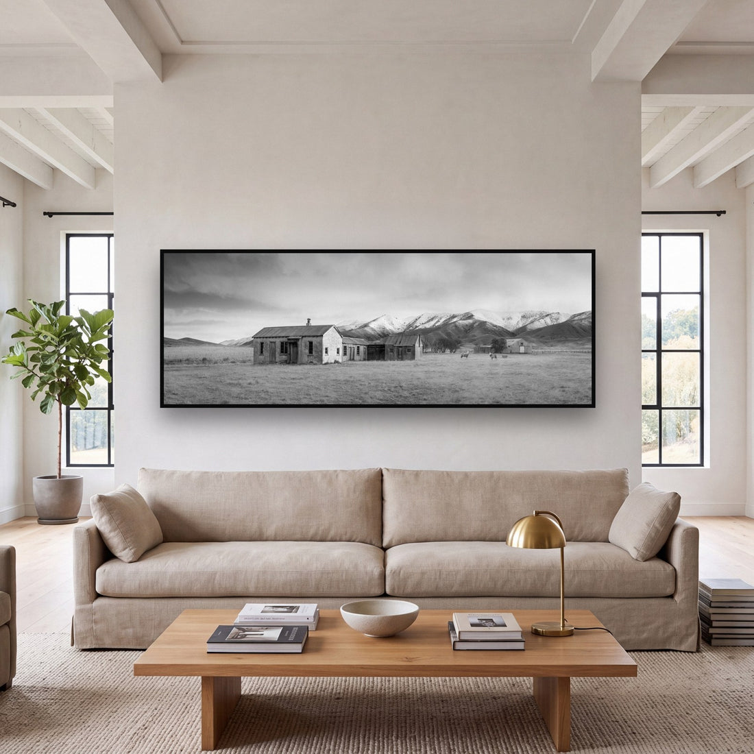 Large black and white fine art print of a forgotten farm ruin in the New Zealand high country by Stephen Milner, shown in a styled interior