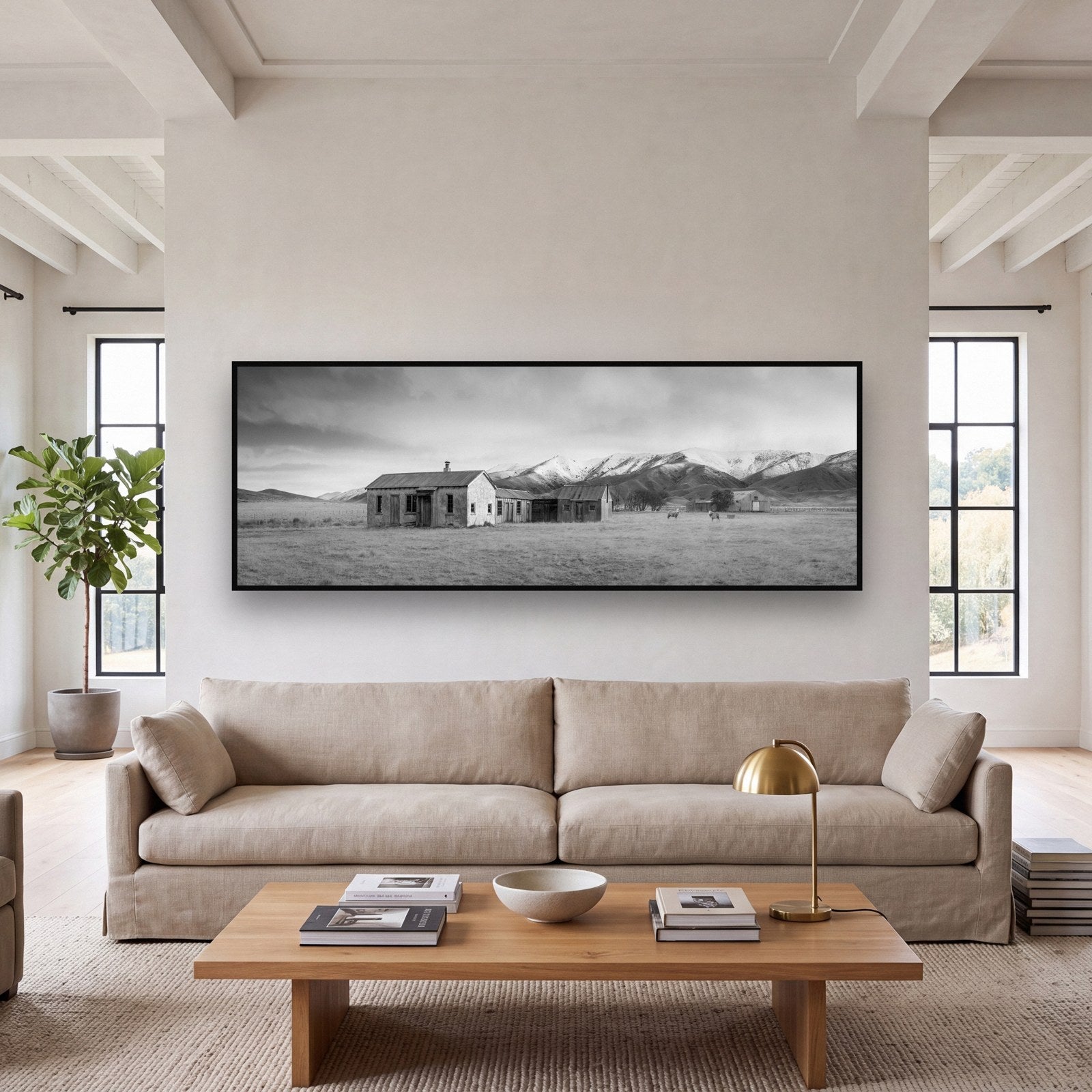 Large black and white fine art print of a forgotten farm ruin in the New Zealand high country by Stephen Milner, shown in a styled interior