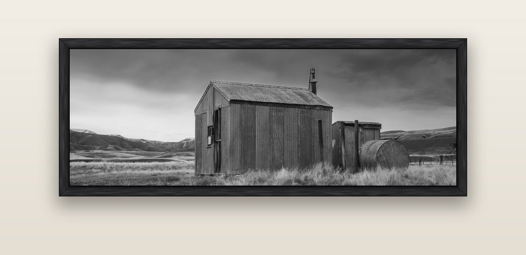 Whispers of Solitude, The Iron Hut — black float frame canvas, 152 × 56 cm. New Zealand fine art landscape wall art by Stephen Milner.