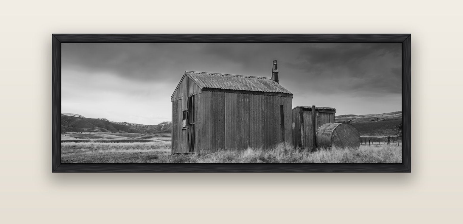 Whispers of Solitude, The Iron Hut — black float frame canvas, 152 × 56 cm. New Zealand fine art landscape wall art by Stephen Milner.
