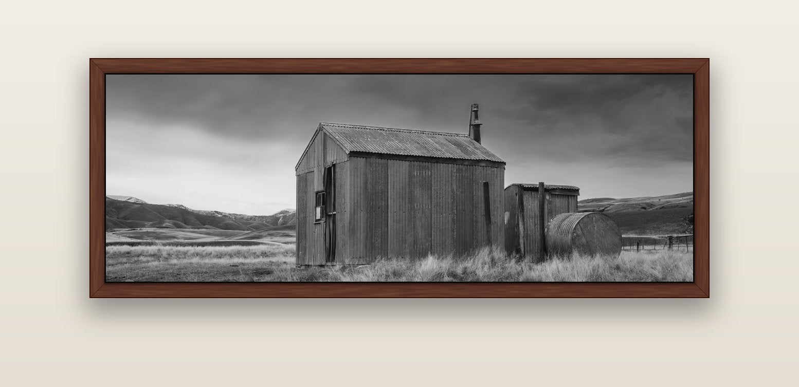 Whispers of Solitude, The Iron Hut — brown float frame canvas, 152 × 56 cm. New Zealand fine art landscape wall art by Stephen Milner.